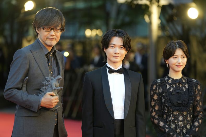 El director de Godzilla Minus One, Takashi Yamazaki, de izquierda a derecha, y los actores Ryunosuke Kamiki y Minami Hamabe posan en la alfombra roja antes de la ceremonia inaugural de la 36a edición del Festival Internacional de Cine de Tokio en Tokio, Japón el 23 de octubre de 2023. (Foto AP/Shuji Kajiyama)