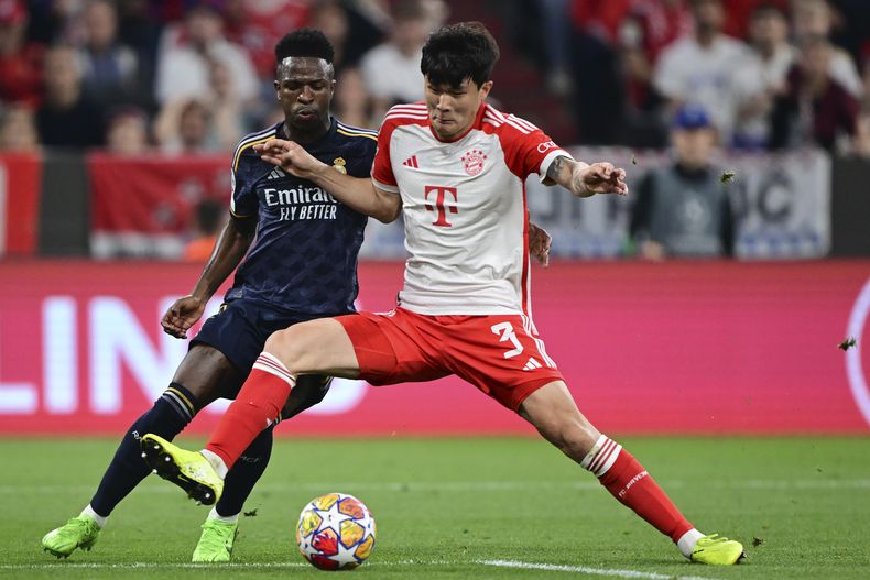 Kim Min-Jae del Bayern de Múnich (derecha) disputa el balón ante el brasileño del Real Madrid Vinicius Junior durante el partido de ida de semifinales de Liga de Campeones en el Allianz Arena en Múnich, Alemania, el martes 30 de abril de 2024. (AP Foto/Christian Bruna)