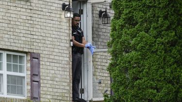 Un miembro del Departamento de Policía de Florence, Kentucky, frente a la puerta de una casa que fue escenario de un tiroteo, el sábado 6 de julio de 2024, en Florence, Kentucky. (AP Foto/Carolyn Kaster)