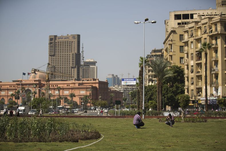 Un joven egipcio posa para una fotograf&iacute;a mientras trabajadores colocan vegetaci&oacute;n en la Plaza Tahrir, en El Cairo, Egipto, el mi&eacute;rcoles 2 de octubre de  2013. (Foto AP/Hassan Ammar)