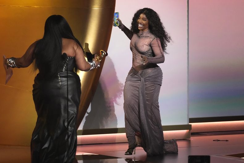 Lizzo, izquierda, entrega el premio a mejor canción R&B a SZA por Snooze en la 66a entrega anual de los Premios Grammy el domingo 4 de febrero de 2024 en Los Ángeles. (Foto AP/Chris Pizzello)