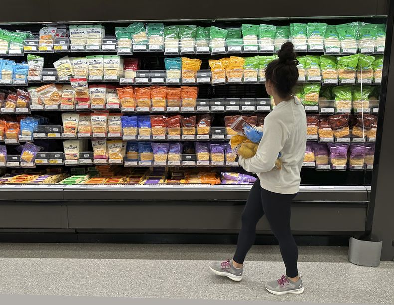 Una mujer pasa frente al área de quesos en una tienda de la cadena Target, el miércoles 4 de octubre de 2023, en Sheridan, Colorado. (AP Foto/David Zalubowski)