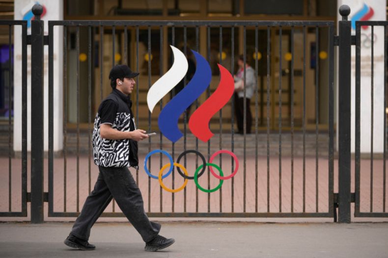 Una persona camina enfrente de los aros olímpicos en las oficinas del Comité Olímpico Ruso en Moscú el martes 7 de julio del 2026. (AP Foto/Pavel Bednyakov)