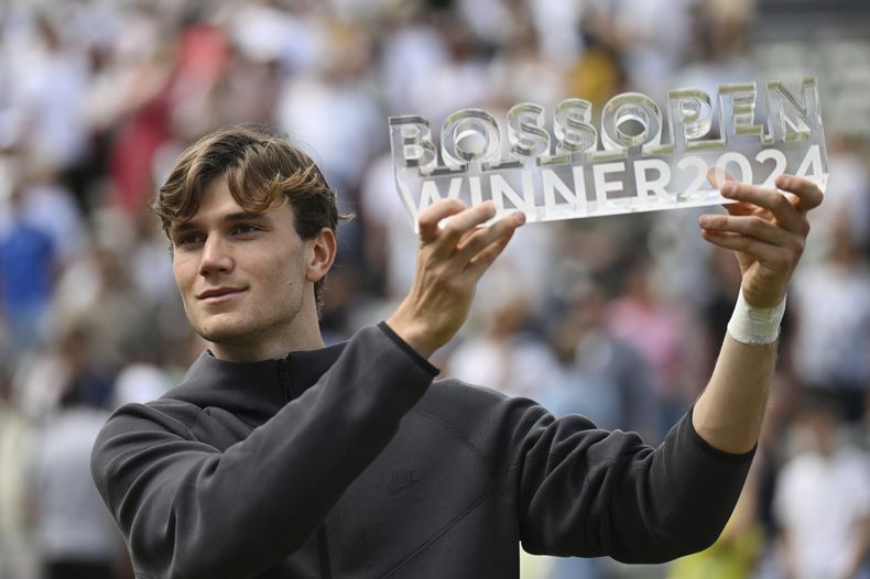 Jack Draper con el trofeo de campeón tras derrotar a Matteo Berrettini en la final del Abierto de Stuttgart, el domingo 16 de junio de 2024. (Marijan Murat/dpa vía AP)