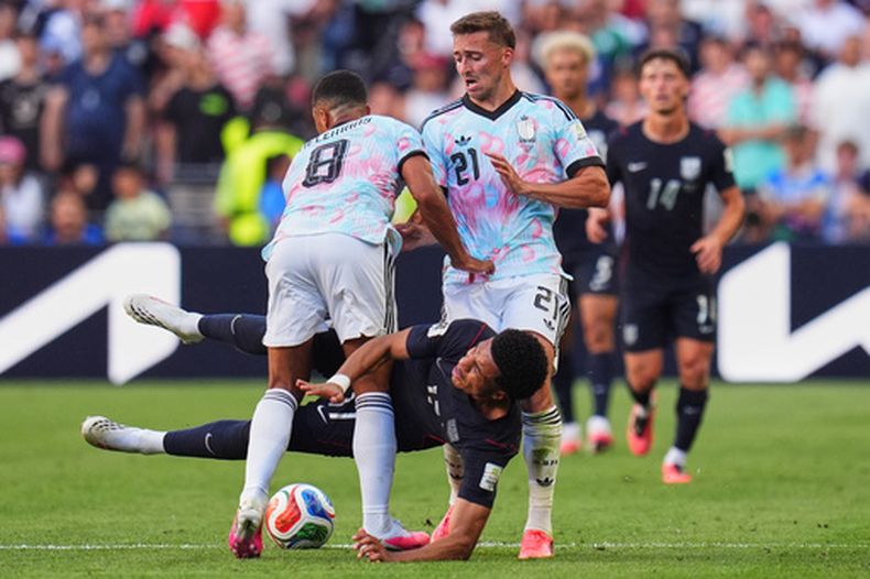 El estadounidense Malik Tillman cae entre los belgas Youri Tielemans y Timothy Castagne durante el partido de los octavos de final del Mundial, el lunes 6 de julio de 2026, en Seattle. (AP Foto/Manu Fernpandez)
