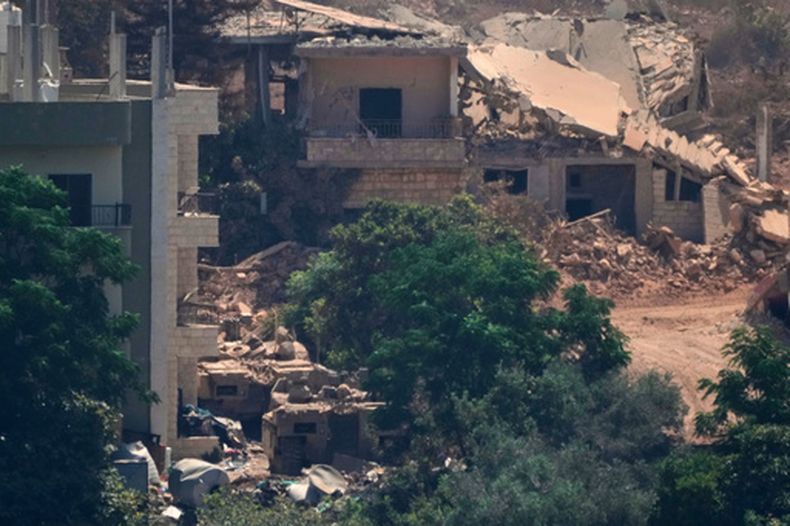 Vehículos militares israelíes (a la izquierda) yacen apostados entre viviendas en la localidad de Zawtar al-Sharqiyah —ocupada por fuerzas israelíes—, en esta fotografía captada desde el pueblo de Zawtar al-Gharbieh, el miércoles 5 de agosto de 2026, en el sur del Líbano. (AP Foto/Mohammed Zaatari)