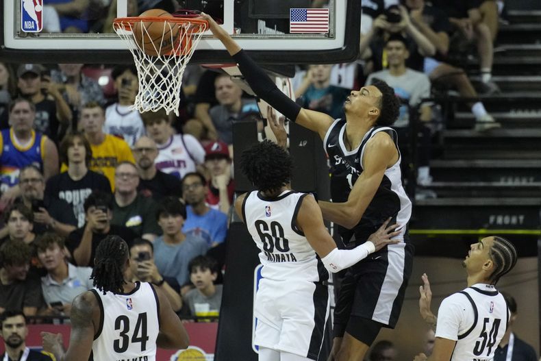 Victor Wembanyama, de los Spurs de San Antonio, retaca el balón sobre Justin Minaya, de los Trail Blazers de Portland, durante la primera mitad del juego de baloncesto de la Liga de Verano de la NBA, el domingo 9 de julio de 2023, en Las Vegas. (AP Foto/John Locher)