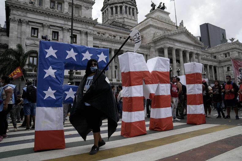 ARCHIVO - Un manifestante camina frente a unas letras en grande del FMI, durante una protesta en las afueras del Congreso mientras los legisladores se preparan para votar por una ley que ratificara el acuerdo del gobierno con el Fondo Monetario Internacional para refinanciar el préstamo de 45.000 millones, en Buenos Aires, Argentina, el jueves 10 de marzo de 2022. Argentina confirmó el jueves 29 de junio de 2023 que pagó un desembolso de 2.700 millones de dólares al FMI en espera de renegociar el acuerdo de préstamo. (AP Foto/Rodrigo Abd, Archivo)