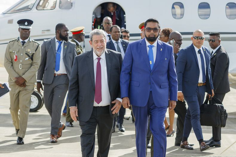 El presidente de Guyana Irfaan Ali (d) con el primer ministro de San Vicente y las Granadinas, Ralph Gonsalves, cuando Ali llegaba a Argyle, San Vicente, el 14 de diciembre de 2023. (Foto AP /Lucanus D. Ollivierre)