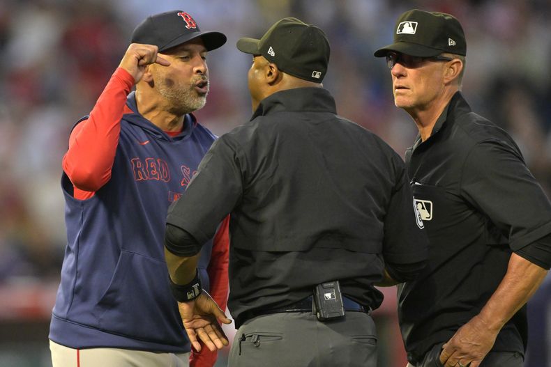 El mánager de los Medias Rojas de Boston Alex Cora discute con el umpire Alan Porter y Jim Wolf tras ser expulsado en la quinta entrada ante los Angelinos de Los Ángeles el lunes 23 de junio del 2025. (AP Foto/Jayne Kamin-Oncea)