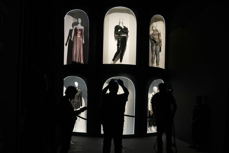 Periodistas y visitantes se toman fotografías y videos frente a piezas de vestuario en una galería emergente con una exposición sobre la cantante colombiana Shakira en la colonia Roma Norte de la Ciudad de México, el jueves 20 de marzo de 2025. (Foto AP/Marco Ugarte)