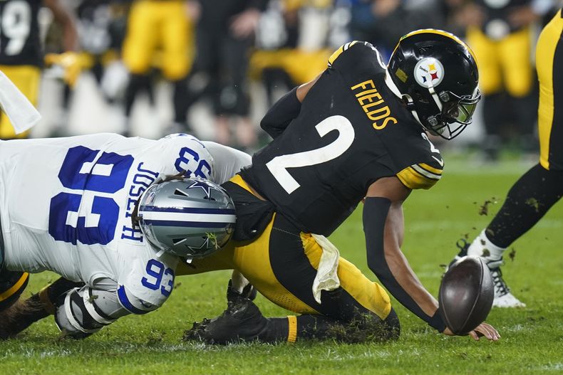 El quarterback de los Steelers de Pittsburgh, Justin Fields (2), pierde el balón mientras es golpeado por el tackle defensivo de los Cowboys de Dallas, Linval Joseph (93), durante la primera mitad el domingo 6 de octubre de 2024, en Pittsburgh. Fields recuperó el balón suelto. (AP Foto/Matt Freed)