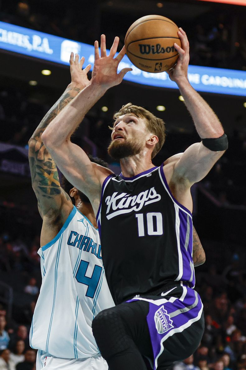El lituano Domantas Sabonis, alero de los Kings de Sacramento, salta hacia la canasta frente a Nick Richards, de los Hornets de Charlotte, el miércoles 10 de enero de 2024 (AP Foto/Nell Redmond)