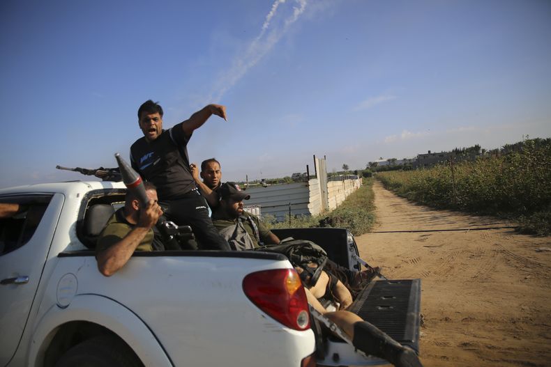 Insurgentes palestinos regresan a la Franja de Gaza en una camioneta con el cuerpo de Shani Louk, un ciudadano con doble nacionalidad israelí y alemana, el 7 de octubre de 2023. Hamás, el grupo insurgente que gobierna la Franja de Gaza, llegó a cabo un ataque sin precedentes y por varios frente sobre Israel al amanecer del 7 de octubre, disparando miles de proyectiles mientras docenas de combatientes cruzaban la fortificada frontera para infiltrarse en varias localidades por tierra, mar y aire, tomando al país por sorpresa durante un importante feriado. (AP Foto/Ali Mahmud)