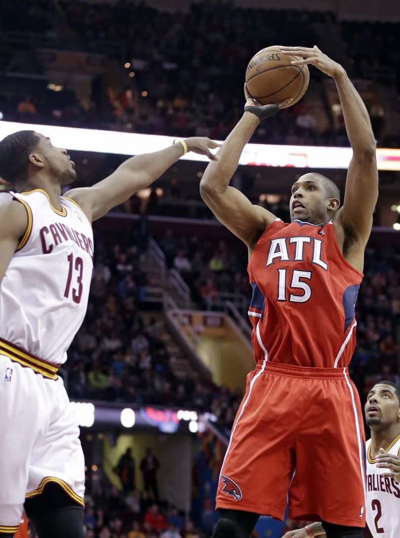 El dominicano Al Horford (15), de los Hawks de Atlanta, lanza por encima de Tristan Thompson (13), de los Cavaliers de Cleveland, durante el primer cuarto de una partido de la NBA, el jueves 26 de diciembre de 2013, en Cleveland. Los Hawks ganaron127-125