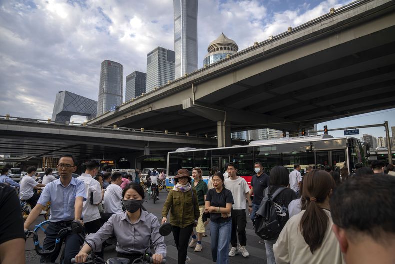ARCHIVO - Pasajeros caminan por un cruce en la hora punta de la tarde en el distrito céntrico de negocios en Beijing, el 13 de junio de 2023. La economía china creció un 6,3% en el segundo trimestre, por debajo de las expectativas incluso tras el casi paralizado crecimiento del mismo periodo del año anterior. (AP Foto/Mark Schiefelbein, Archivo)