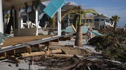 ARCHIVO - La residente Kerry Flyyn y una amiga caminan junto a una casa destrozada por el huracán Milton, en Englewood, Florida, el 13 de octubre de 2024. (AP Foto/Rebecca Blackwell, Archivo)