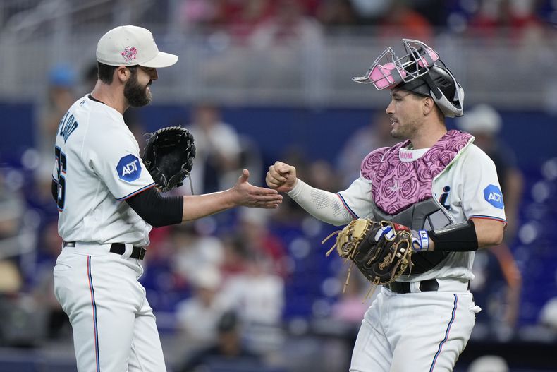 Dylan Floro, izquierda, relevista de los Marlins de Miami, y el receptor Nick Fortes se felicitan mutuamente después de que los Marlins derrotaron a los Rojos de Cincinnati 3-1 en el juego de béisbol, el domingo 14 de mayo de 2023, en Miami. (AP Foto/Wilfredo Lee)