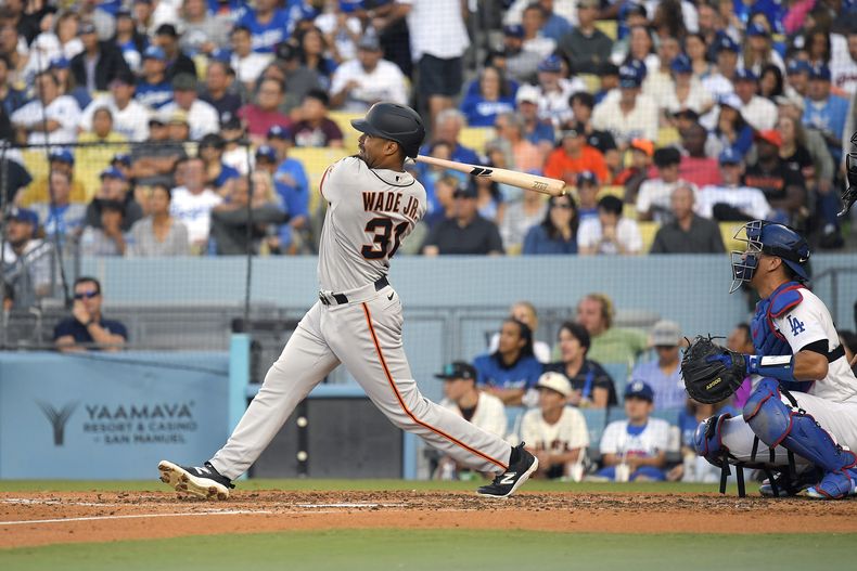 LaMonte Wade Jr. de los Gigantes de San Francisco batea un jonrón de tres carreras en la quinta entrada frente al cátcher de los Dodgers de Los Ángeles Austin Barnes el sábado 17 de junio del 2023. (AP Foto/Mark J. Terrill)