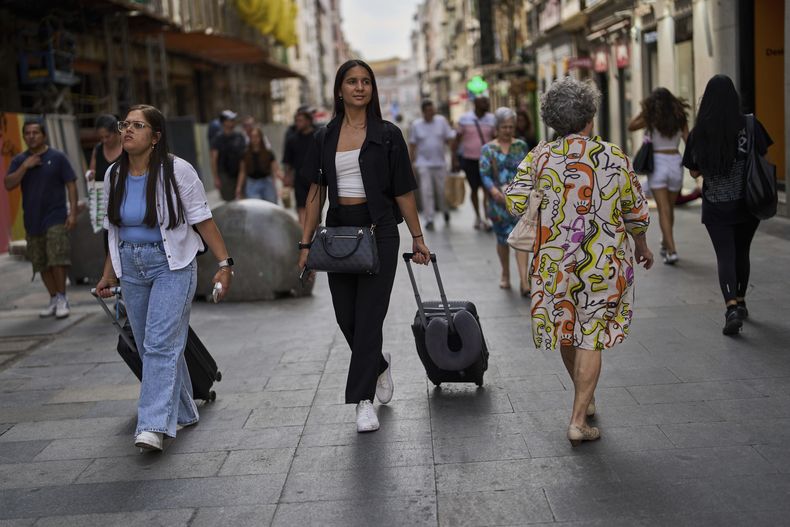 ARCHIVO – Un grupo de turistas traslada su equipaje en el centro de Madrid, España, el miércoles 3 de junio de 2025. (AP Foto/Manu Fernandez, Archivo)