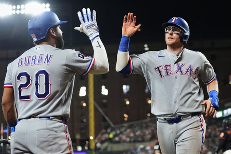 Danny Jansen (derecha), festeja con el dominicano Ezequiel Durán, de los Rangers de Texas, tras batear un jonrón de tres carreras frente a los Orioles de Baltimore, el martes 31 de marzo de 2026 (AP Foto/Stephanie Scarbrough)
