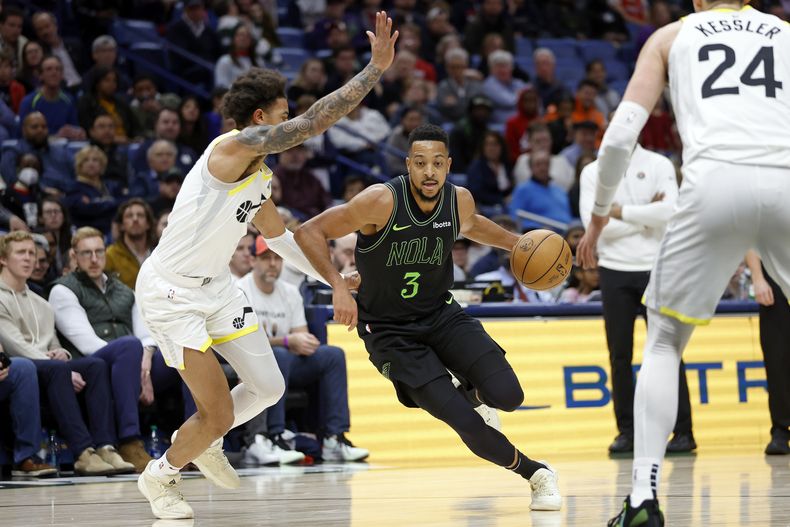 CJ McCollum, de los Pelicans de Nueva Orleáns, avanza a la cesta frente a Keyonte George (izquierda), del Jazz de Utah, el martes 23 de enero de 2024 (AP Foto/Tyler Kaufman)