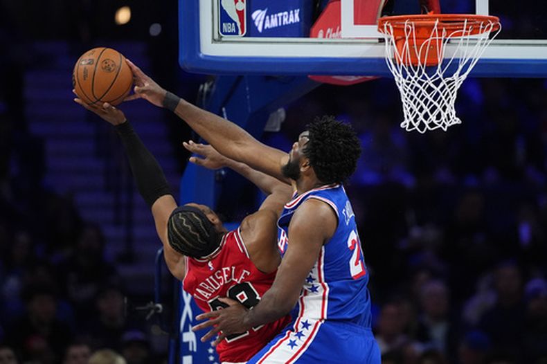 Joel Embiid, derecha, de los 76ers de Filadelfia, bloquea un tiro de Guerschon Yabusele, de los Bulls de Chicago, durante la primera mitad del juego de baloncesto de la NBA, el miércoles 25 de marzo de 2026, en Filadelfia. (AP Foto/Matt Slocum)