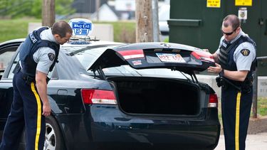 americateve | Agentes de la Real Polic&iacute;a Montada de Canad&aacute; revisan el ba&uacute;l de un texi en &iexcl;&iexcl;Moncton, Nuew Brunswick, el jueves, 5 de junio del 2014, como parte de la operaci&oacute;n de b&ntilde;usqueda de un honmbre que mat&oacute; a ti