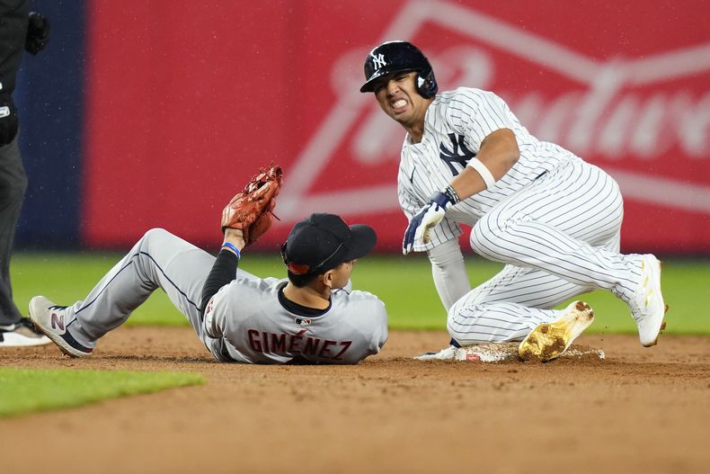Oswald Peraza, de los Yanquis de Nueva York, reacciona después de sufrir una lesión al barrerse al concretar el robo de segunda base, ante la mirada de Andrés Giménez, de los Guardianes de Cleveland, durante la novena entrada del juego de béisbol, el miércoles 3 de mayo de 2023, en Nueva York. (AP Foto/Frank Franklin II)