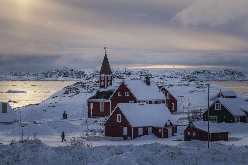ARCHIVO - Una mujer camina cerca de una iglesia en Nuuk, Groenlandia, el viernes 7 de marzo de 2025. (AP Foto/Evgeniy Maloletka, Archivo)
