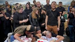 Familiares y amigos en el funeral de una niña que murió en un ataque ruso contra Vinnytsia, Ucrania, el sábado 17 de julio de 2022. (AP Foto/Efrem Lukatsky)