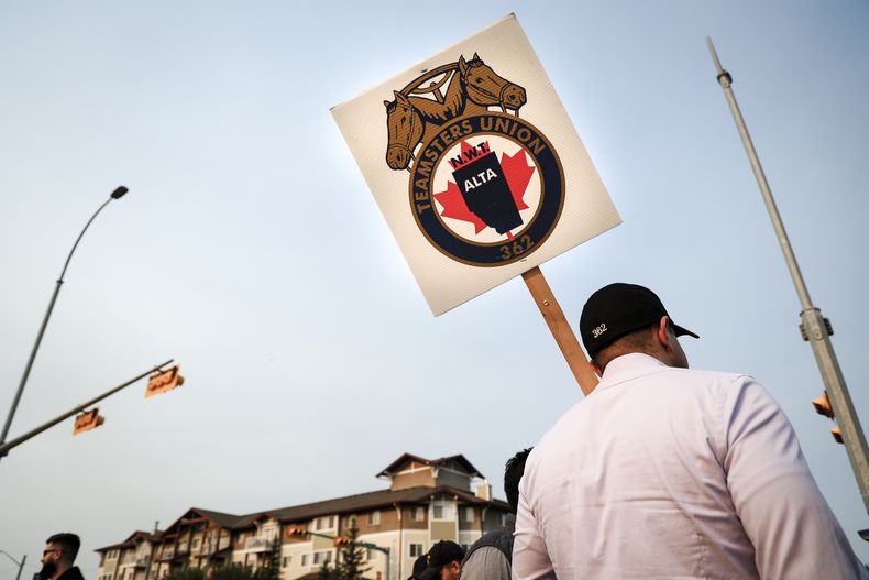 Miembros del sindicato Teamsters protestan afuera de la sede de la compañía ferroviaria CPKC en Calgary, Canadá, el viernes 23 de agosto de 2024. (Jeff McIntosh/The Canadian Press vía AP)