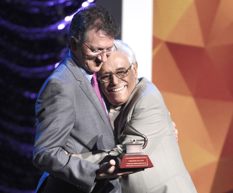 ARCHIVO - Gabriel Abaroa Jr., presidente y director ejecutivo de la Academia Latina de la Grabación, izquierda, entrega el premio del consejo directivo al poeta y músico venezolano Chelique Sarabia, en la gala de los premios especiales de la Academia Latina de la Grabación, en Las Vegas, el 18 de noviembre de 2015. (Foto Chris Pizzello/Invision/AP archivo)