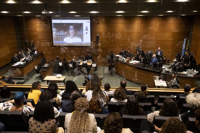 Fernanda Goncalves Chaves, asistente de la concejala brasileña asesinada Marielle Franco, en la pantalla, testifica en el juicio a los acusados de matar a Franco, en un tribunal de Rio de Janeiro, el 30 de octubre del 2024. (AP Foto/Bruna Prado)