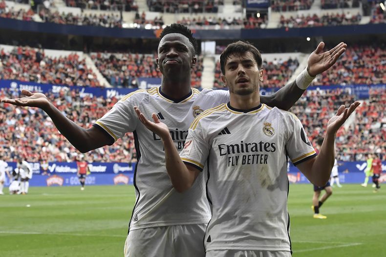 Brahim Díaz (derecha) y Vinicius Junior celebran el gol de Díaz para el Real Madrid ante Osasuna en el partido de la Liga española, el sábado 16 de marzo de 2024, en Pamplona. (AP Foto/Álvaro Barrientos)