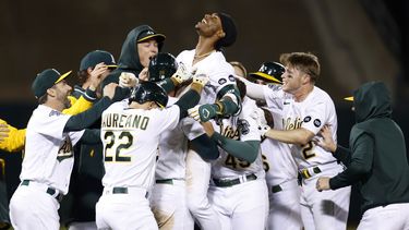 Esteury Ruiz (centro), de los Atléticos de Oakland, celebra con sus compañeros la victoria tras sacudir el sencillo del triunfo en el 12mo inning del juego de la MLB que enfrentó a su equipo con los Diamondbacks de Arizona, en Oakland, California, el 16 de mayo de 2023. (AP Foto/Jed Jacobsohn)