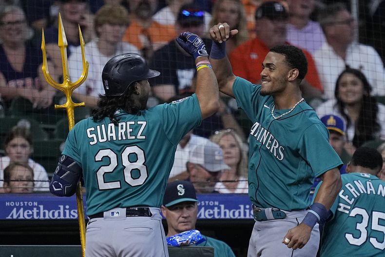 Eugenio Suárez, de los Marineros de Seattle, celebra con Julio Rodríguez después de batear jonrón de dos carreras durante la segunda entrada del juego de béisbol en contra de los Astros de Houston, el domingo 20 de agosto de 2023, en Houston. (AP Foto/Kevin M. Cox)