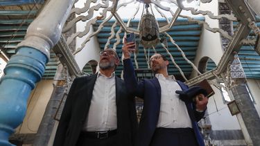 El rabino Yusuf Hamra, izquierda, y su hijo Henry toman fotografías en su visita a la sinagoga al-Raqi en la antigua ciudad de Damasco, el 18 de febrero de 2025. (AP Foto/Omar Sanadiki)