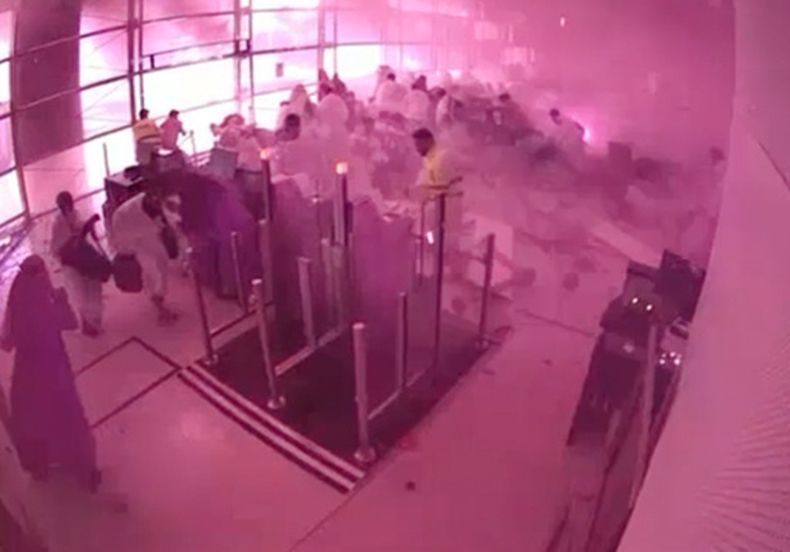 En la imagen, tomada de un video de vigilancia publicado por el Ministerio de Medios de Comunicación de Arabia Saudí, varios pasajeros se cubren mientras las llamas y el humo se extienden en una parte del Aeropuerto Internacional Rey Jalid en Riad, en Arabia Saudí, en lo que las autoridades describen como un ataque contra el aeropuerto, el sábado 10 de octubre de 2026. (Ministerio de Medios de Comunicación de Arabia Saudí vía AP)