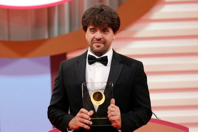 ARCHIVO - El científico estadounidense Karl Deisseroth, profesor de los Departamentos de Bioingeniería y Psiquiatría en la Universidad de Stanford, sostiene su trofeo por la categoría Ciencias de la Vida en la entrega de los Premios Japón, el jueves 13 de abril de 2023 en Tokio. (AP Foto/Eugene Hoshiko, Archivo)