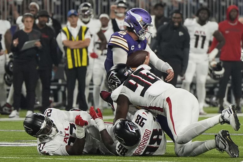 Zach Harrison (96), de los Falcons de Atlanta, captura a J.J. McCarthy (9), quarterback de los Vikings de Minnesota, durante la primera mitad del partido de la NFL, el domingo 14 de septiembre de 2025, en Minneapolis. (AP Foto/Mike Stewart)