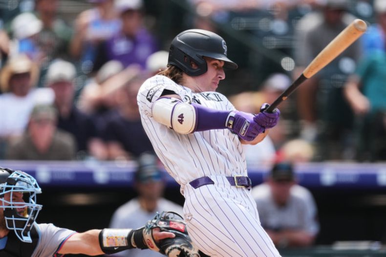 Jake McCarthy, de los Rockies de Colorado, conecta un sencillo productor de dos carreras ante el lanzador relevista de los Marlins de Miami, Calvin Faucher, en la sexta entrada de un partido de béisbol, el jueves 2 de julio de 2026, en Denver. (Foto AP/David Zalubowski)