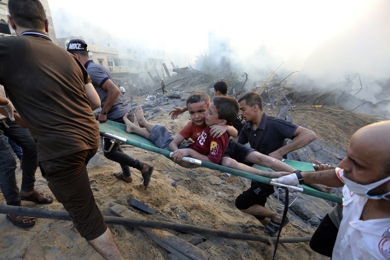 Palestinos sacan a dos niños heridos en un ataque aéreo israelí sobre la Ciudad de Gaza, el 25 de octubre de 2023. (AP Foto/Abed Khaled)