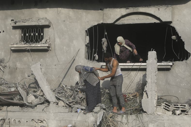 Palestinos evacúan un edificio dañado en un bombardeo israelí en Rafah, el domingo 22 de octubre de 2023, en la Franja de Gaza. (AP Foto/Hatem Ali)