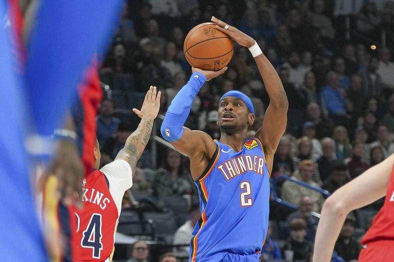 El base del Thunder de Oklahoma City Shai Gilgeous-Alexander lanza el balón sobre el base de los Pelicans de Nueva Orleans Jordan Hawkins en el encuentro del lunes 10 de febrero del 2025. (AP Foto/Kyle Phillips)