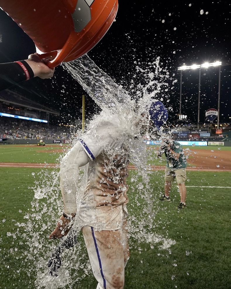 El puertorriqueño MJ Meléndez, de los Reales de Kansas City, es empapado con la hielera tras el triunfo sobre los Mets de Nueva York, el martes 1 de agosto de 2023 (AP Foto/Charlie Riedel)