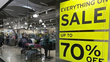 Un anuncio de ofertas cuelga en una ventana de una tienda de ropa el jueves 24 de agosto de 2023, en Lakewood, Colorado. (AP Foto/David Zalubowski)