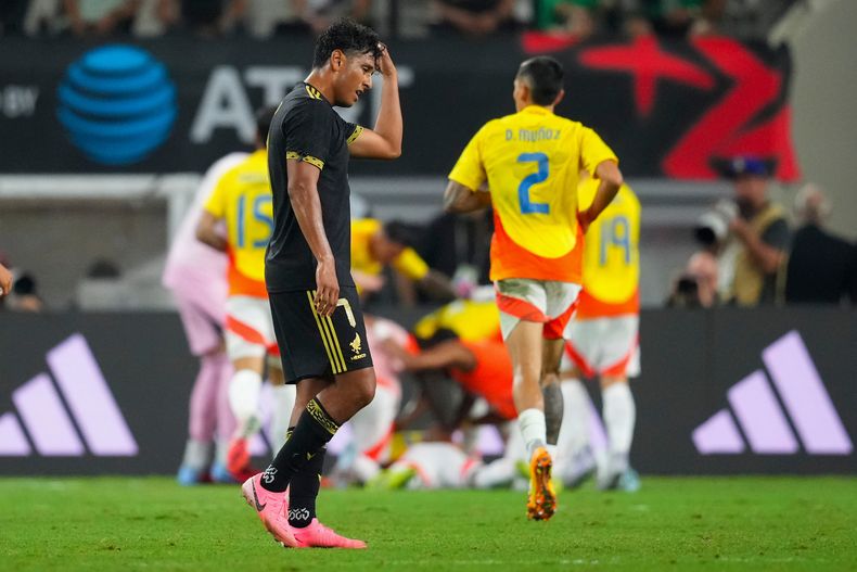 El jugador de México Luis Romo se lamenta mientras jugadores de Colombia festejan un gol en un partido amistoso el sábado 11 de octubre de 2025, en Arlington, Texas. (AP Foto/Julio Cortez)