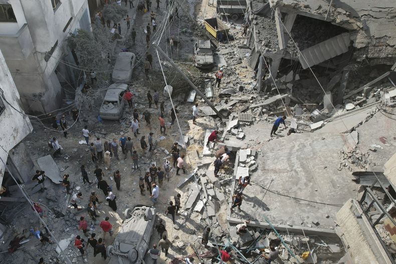 Palestinos buscan sobrevivientes tras un bombardeo israelí en Deir al Balah, el domingo 22 de octubre de 2023, en la Franja de Gaza. (AP Foto/Hatem Moussa)