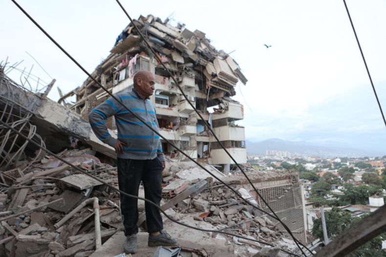 Un hombre permanece de pie entre los escombros de un edificio derrumbado tras un terremoto en La Guaira, Venezuela, el jueves 25 de junio de 2026. (AP Foto/Pedro Mattey)